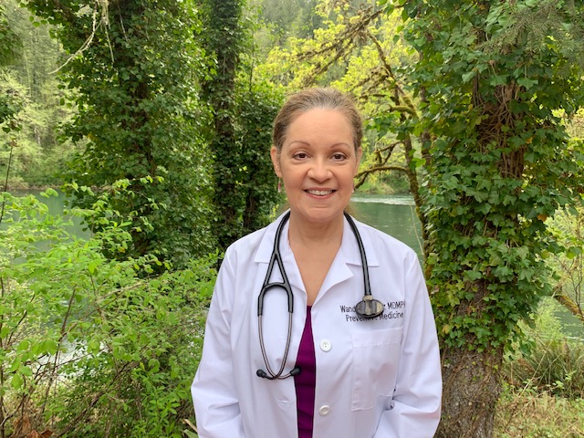 A scientist in a white medical gown cares for plants